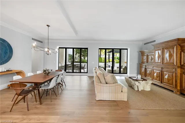 a living room with furniture a chandelier and a large window