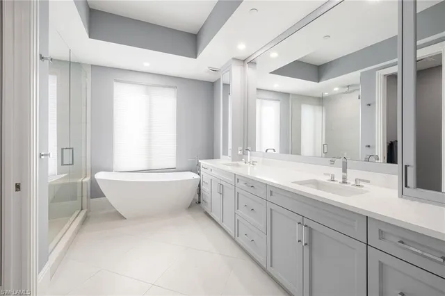 a bathroom with a granite countertop sink mirror and a bathtub