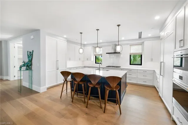 a kitchen with stainless steel appliances kitchen island granite countertop a kitchen island a stove a table and chairs