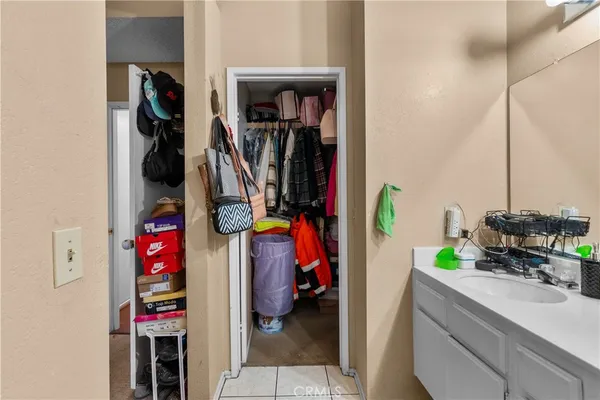 a view of walk in closet with clothes and shoes