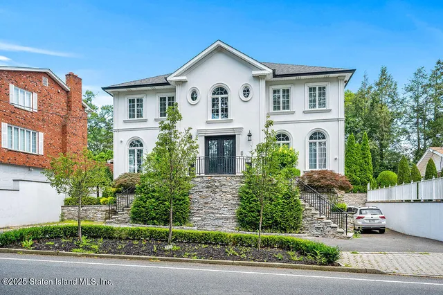 a front view of a house with a yard and trees