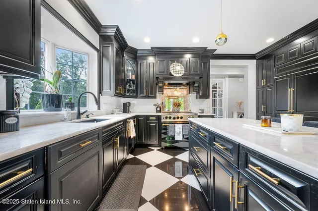 a large kitchen with stainless steel appliances a sink and a large window