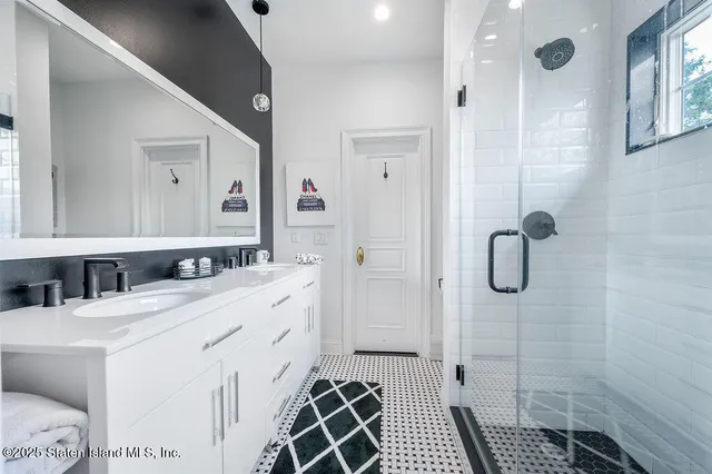 a bathroom with a double vanity sink mirror and shower