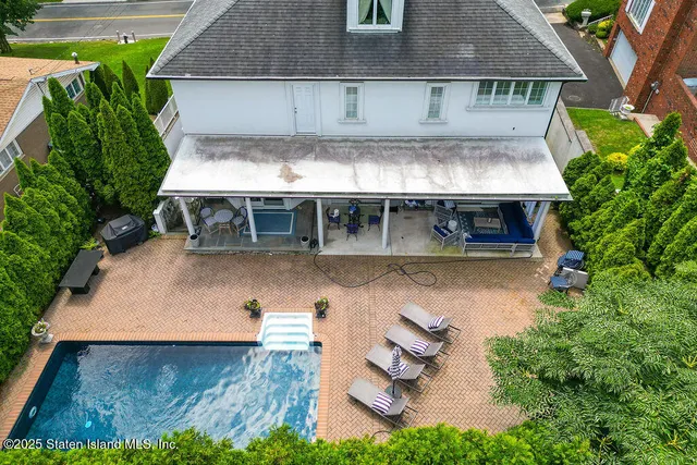 an aerial view of a house with swimming pool garden and patio