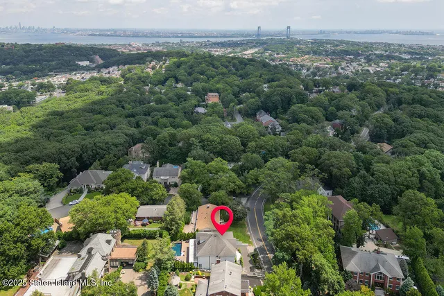 an aerial view of residential houses with outdoor space and trees