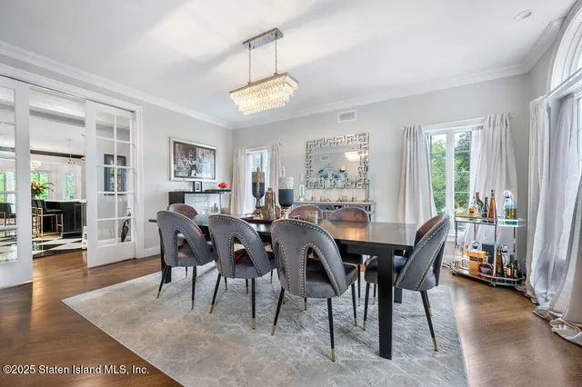 a view of a dining room and livingroom with furniture a rug a potted plant and a painting
