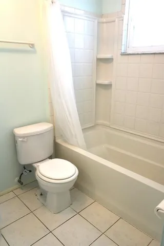 a white toilet sitting next to a bath tub