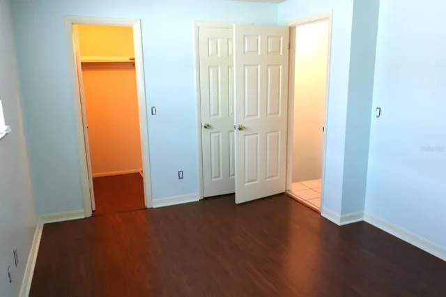 an empty room with wooden floor and closet