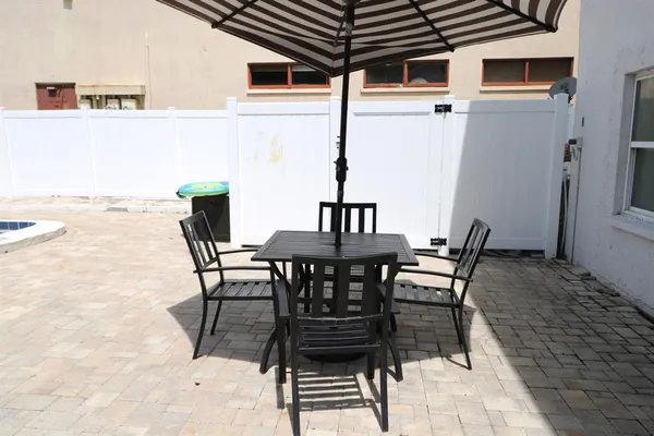 a view of a patio with table and chairs and potted plants
