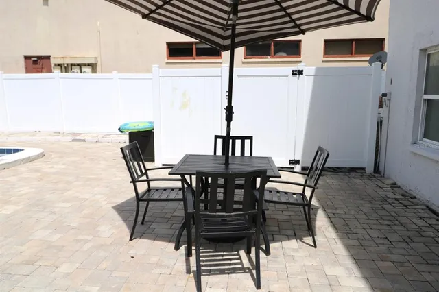 a view of a patio with table and chairs and potted plants