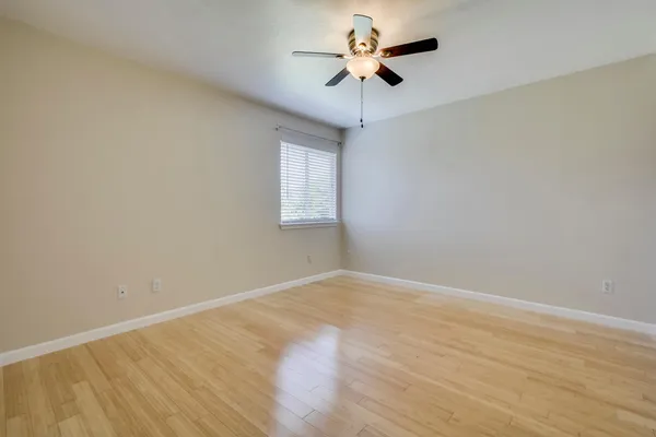 an empty room with a window and a fan