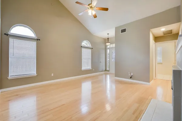 a view of an empty room and window with wooden floor