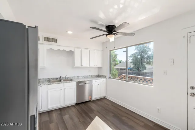 an empty room with a window and a ceiling fan