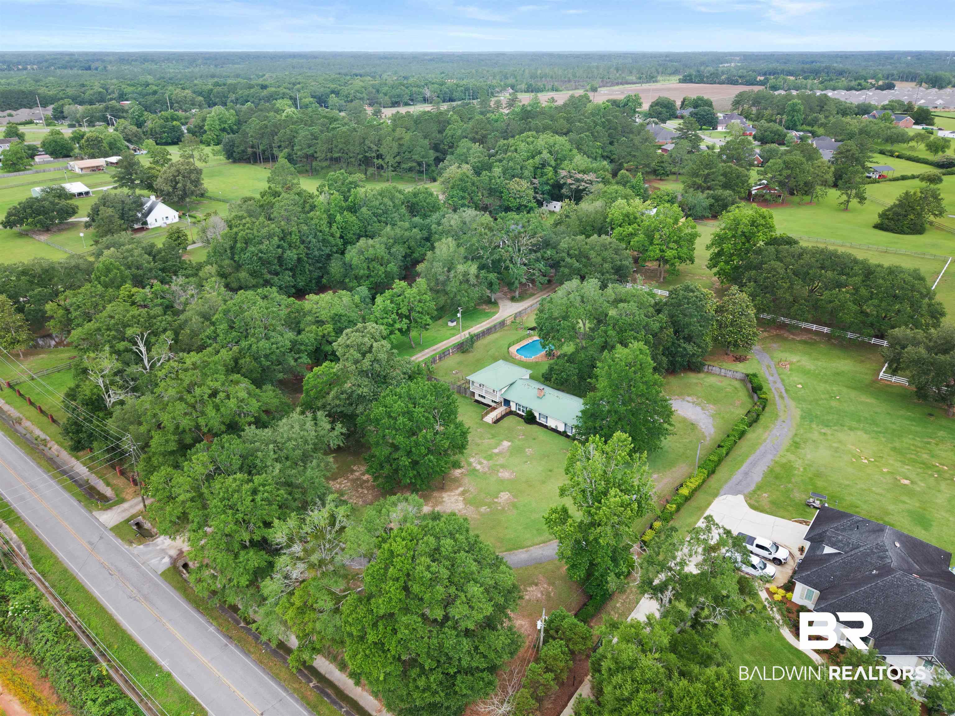 10420 Johnson Road South Mobile, AL 36695 - Photo 67 of 75 Expansive property featuring a single-story residence with a green roof, inground swimming pool, and gravel driveway