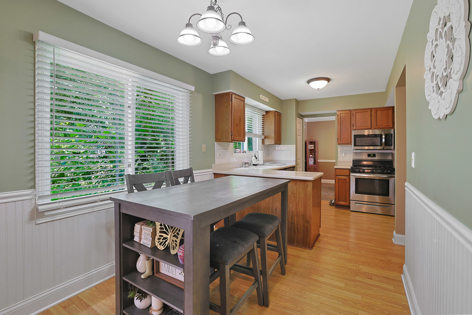 710 Cimarron Drive Cary, IL 60013 - Photo 15 of 31 a kitchen with a table chairs a sink dishwasher window and cabinets