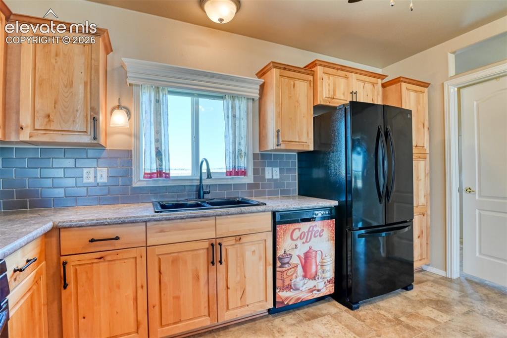 22558 Enoch Road Calhan, CO 80808 - Photo 10 of 50 a kitchen with stainless steel appliances granite countertop a refrigerator and a sink