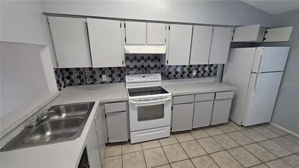 a kitchen that has a sink and a stove in it
