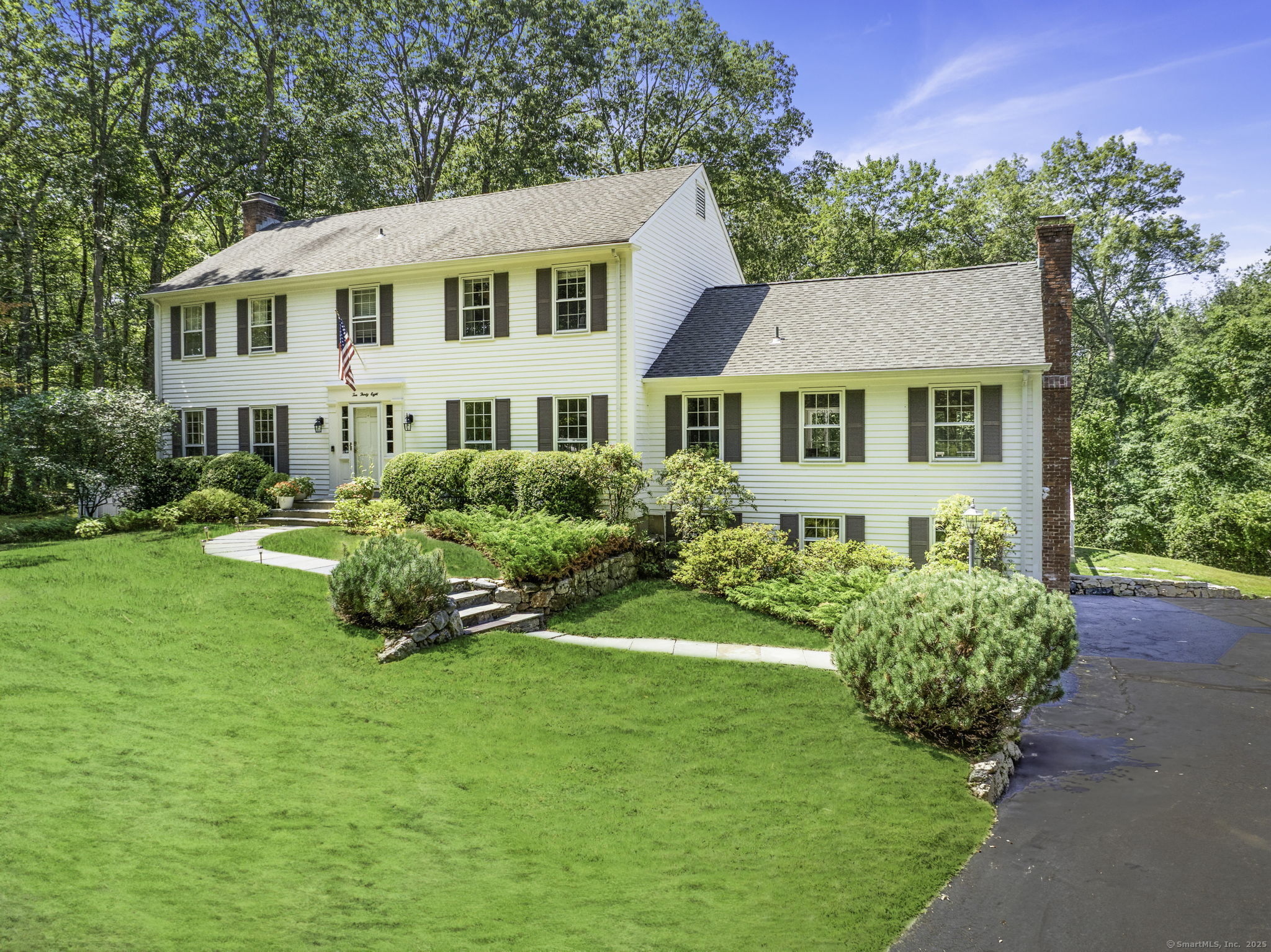 1038 West Road New Canaan, CT 06840 - Photo 1 of 1 a front view of a house with a garden