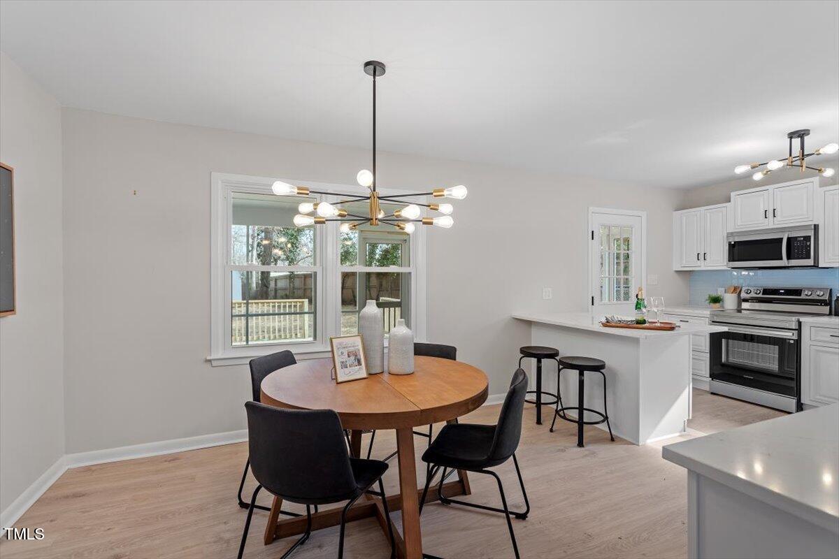 3408 Brentwood Road Raleigh, NC 27604 - Photo 12 of 41 a view of a dining room with furniture window and wooden floor