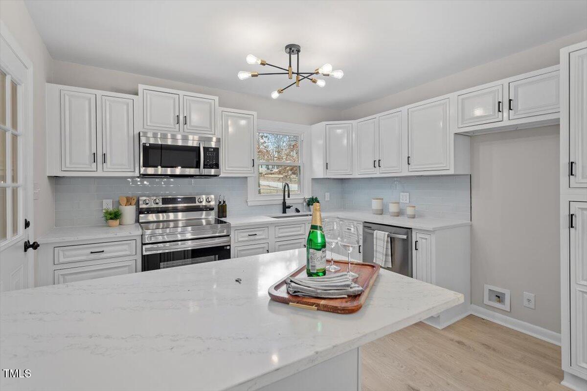 3408 Brentwood Road Raleigh, NC 27604 - Photo 2 of 41 a kitchen with stainless steel appliances a stove a sink and cabinets