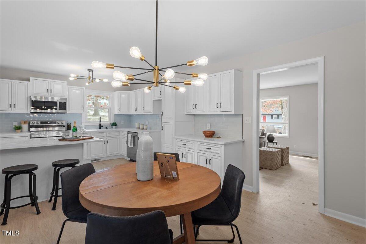 3408 Brentwood Road Raleigh, NC 27604 - Photo 10 of 41 a kitchen with a dining table chairs stainless steel appliances and cabinets