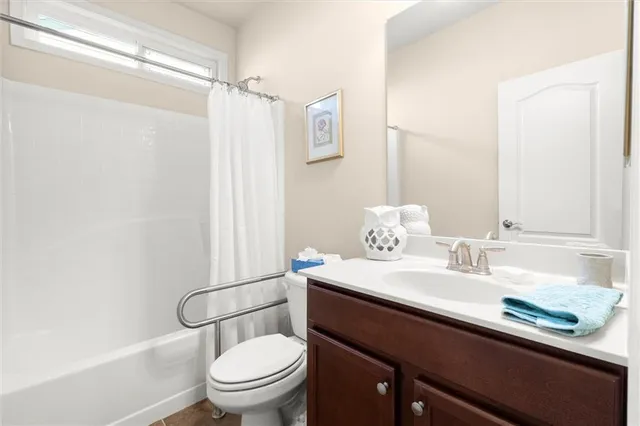 a bathroom with a sink a toilet a mirror and shower