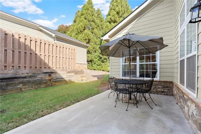 a view of a chair and table in backyard of the house