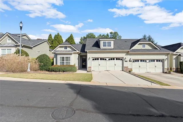 a front view of a house with a yard and potted plants