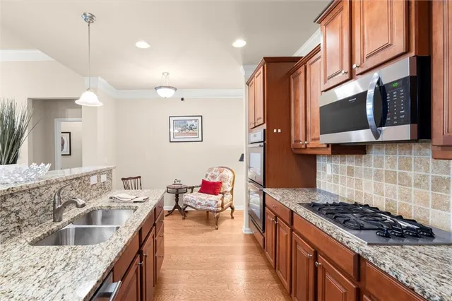 a kitchen with stainless steel appliances granite countertop a sink stove and cabinets