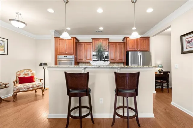 a kitchen with stainless steel appliances kitchen island granite countertop a dining table and chairs in it