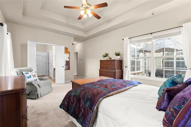 a spacious bedroom with a large bed and a chandelier