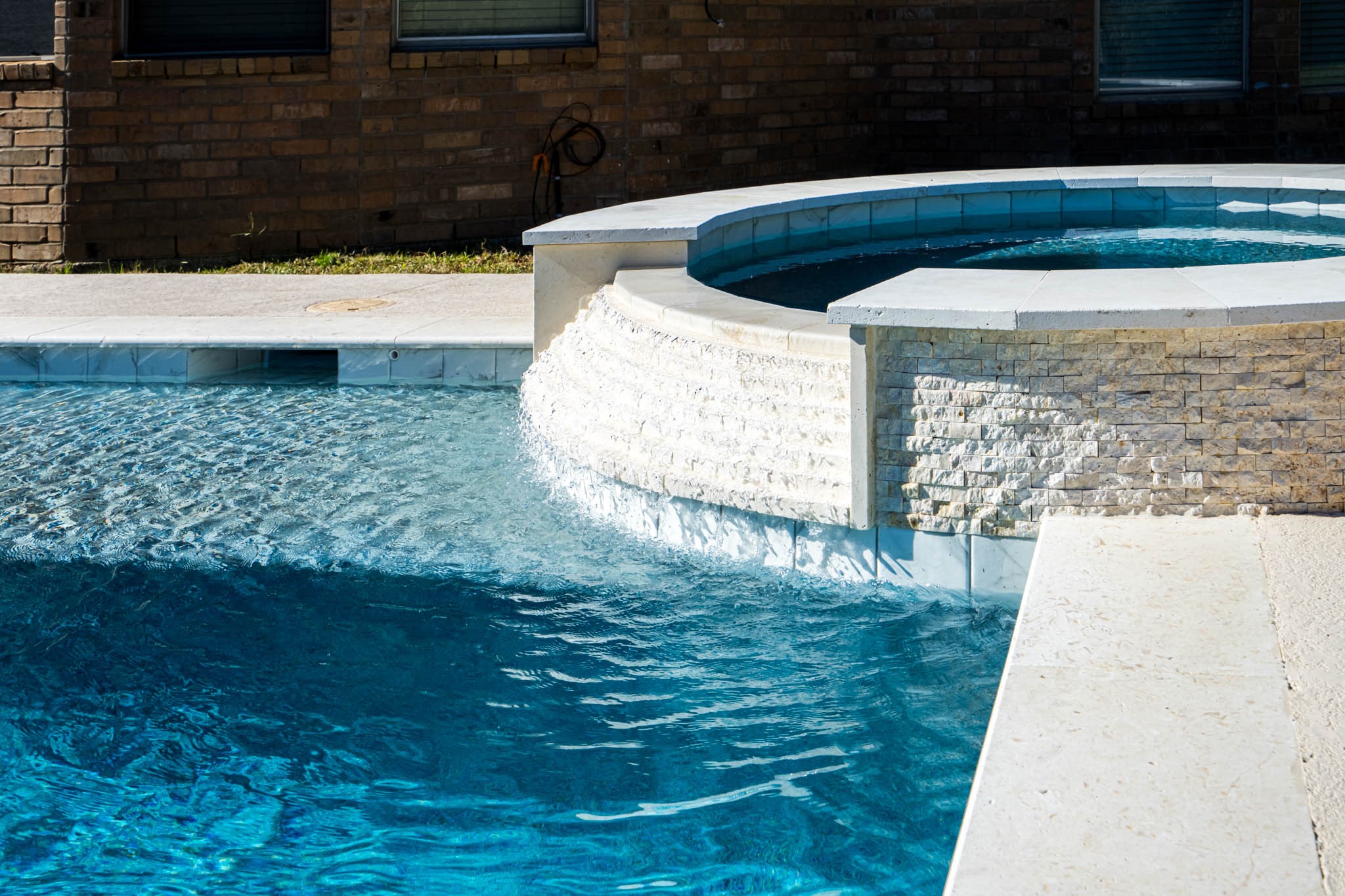 6506 Monte Bello Ridge Lane Houston, TX 77041 - Photo 37 of 39 This photo showcases a backyard pool with a stone waterfall feature, providing a luxurious and relaxing atmosphere. Perfect for entertaining and enjoying outdoor living.