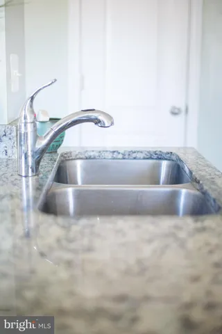 a kitchen with stainless steel appliances kitchen island a table and chair in it