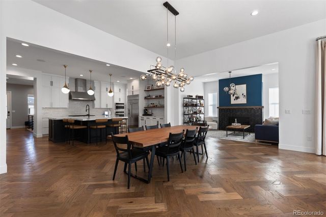a view of a dining room and livingroom with furniture a rug a chandelier and kitchen view