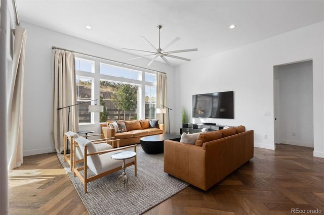 a living room with furniture a flat screen tv and a large window