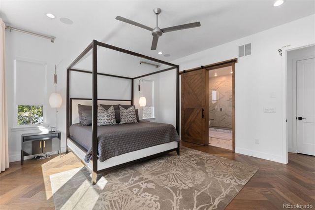 a bedroom with a bed a glass door and furniture