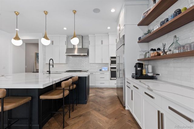 a kitchen with a sink a counter top space appliances and cabinets