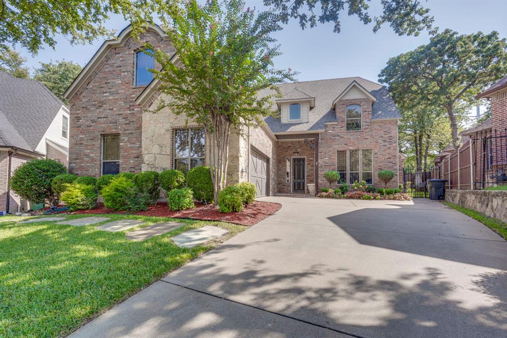 a front view of a house with yard porch and tree