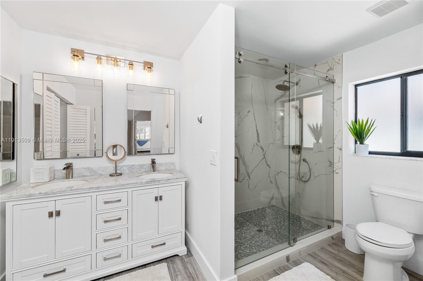 701 Sea Oats Drive, Unit D1 Juno Beach, FL 33408 - Photo 16 of 27 a bathroom with a granite countertop sink a mirror a toilet and shower