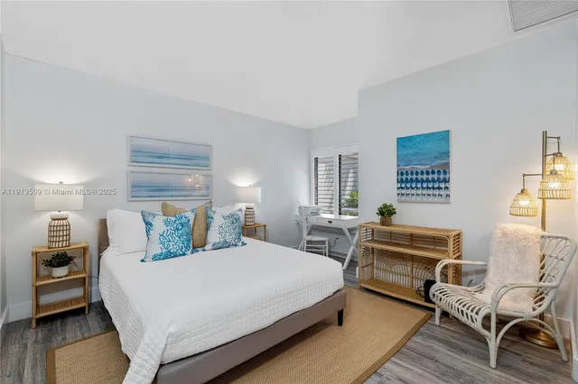 a bedroom with a bed wooden floor and windows