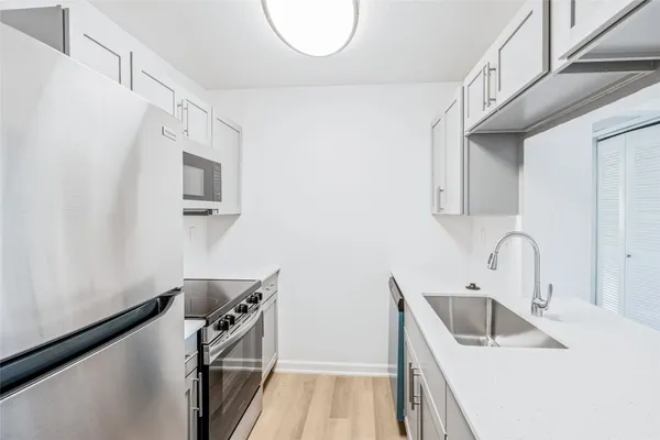 a kitchen with stainless steel appliances a sink a stove and a refrigerator