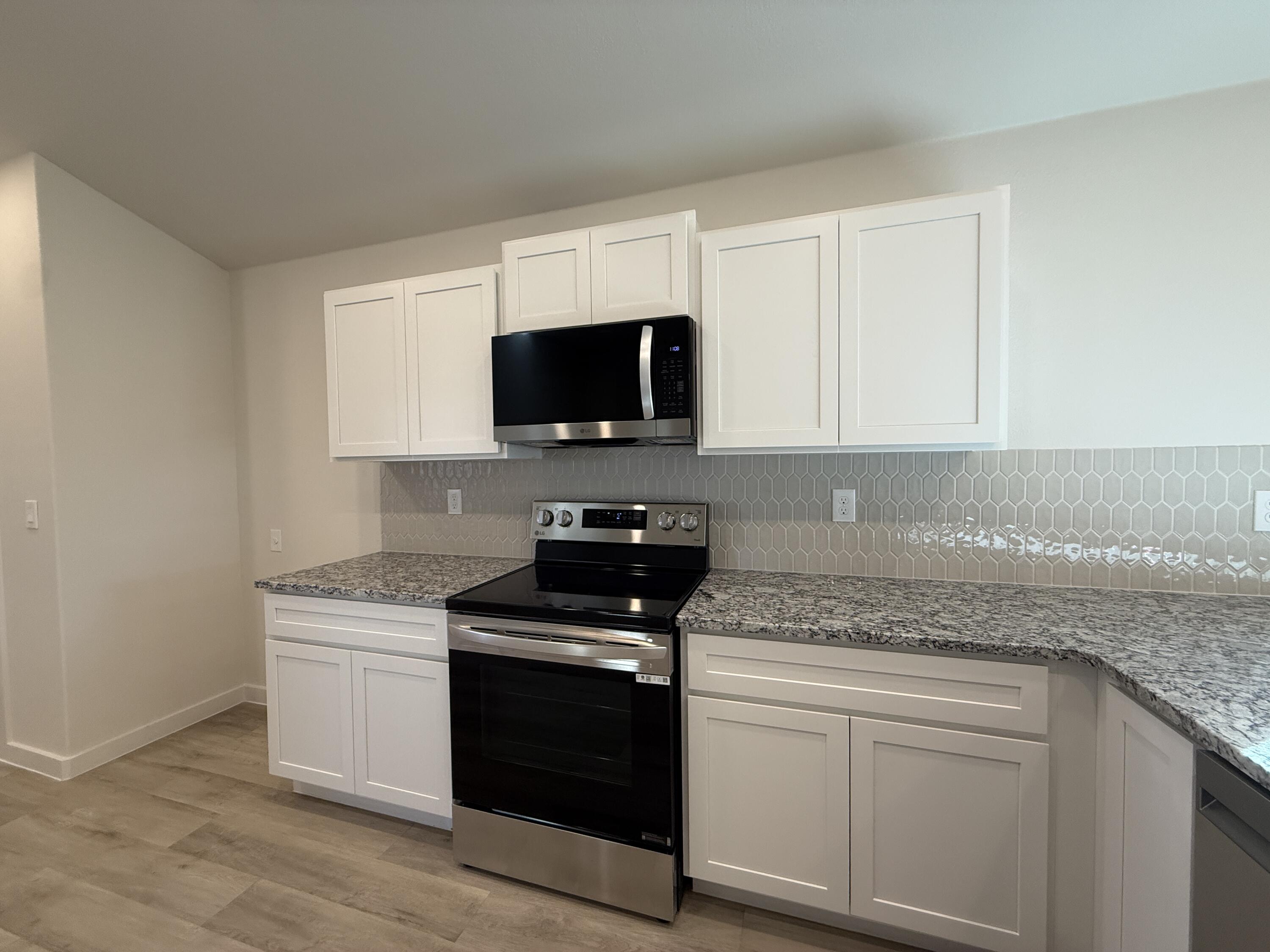 3104 138th Place Lubbock, TX 79423 - Photo 4 of 11 a kitchen with stainless steel appliances granite countertop a stove a sink and a microwave