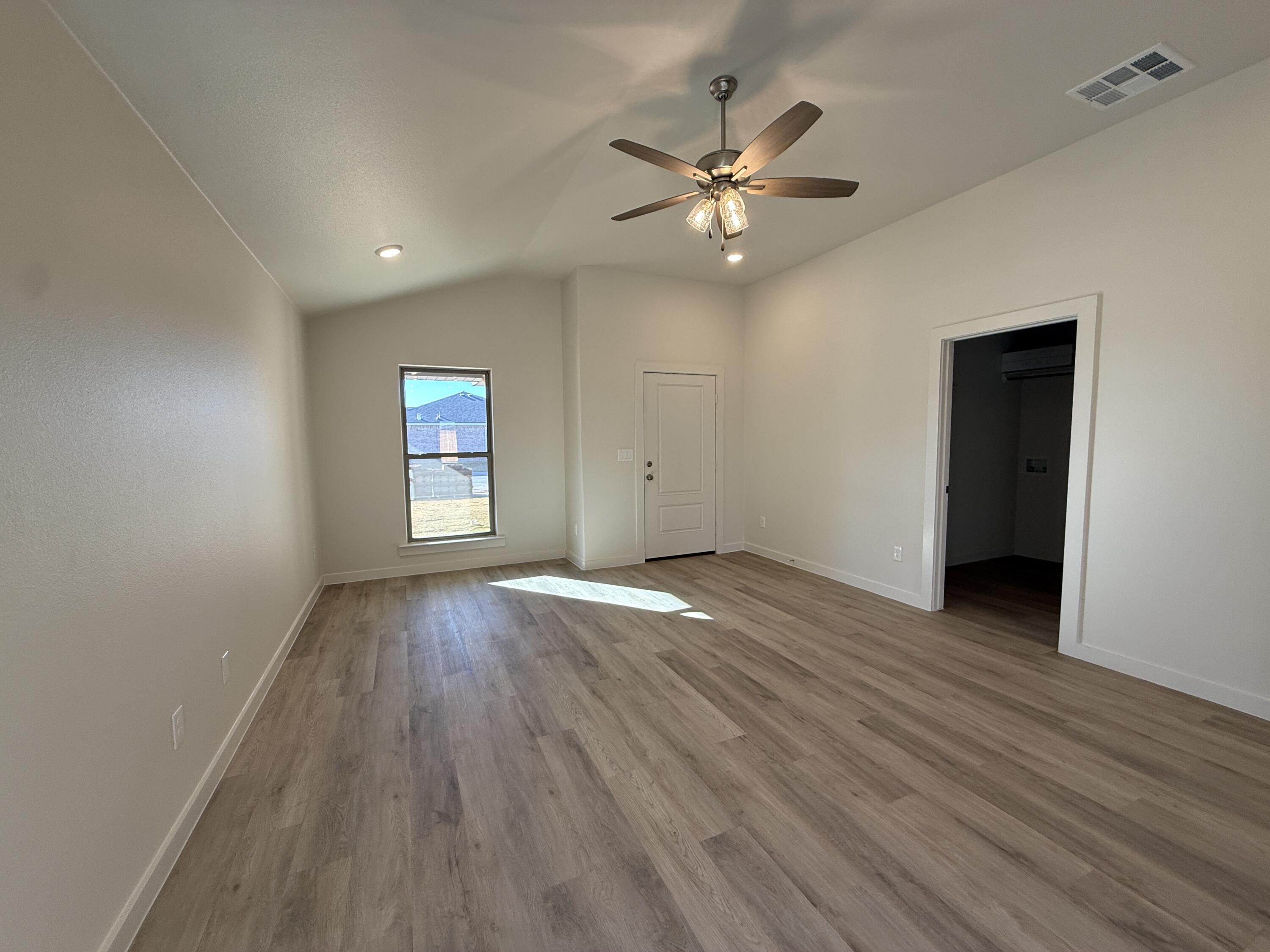 3104 138th Place Lubbock, TX 79423 - Photo 5 of 11 wooden floor in an empty room with a window