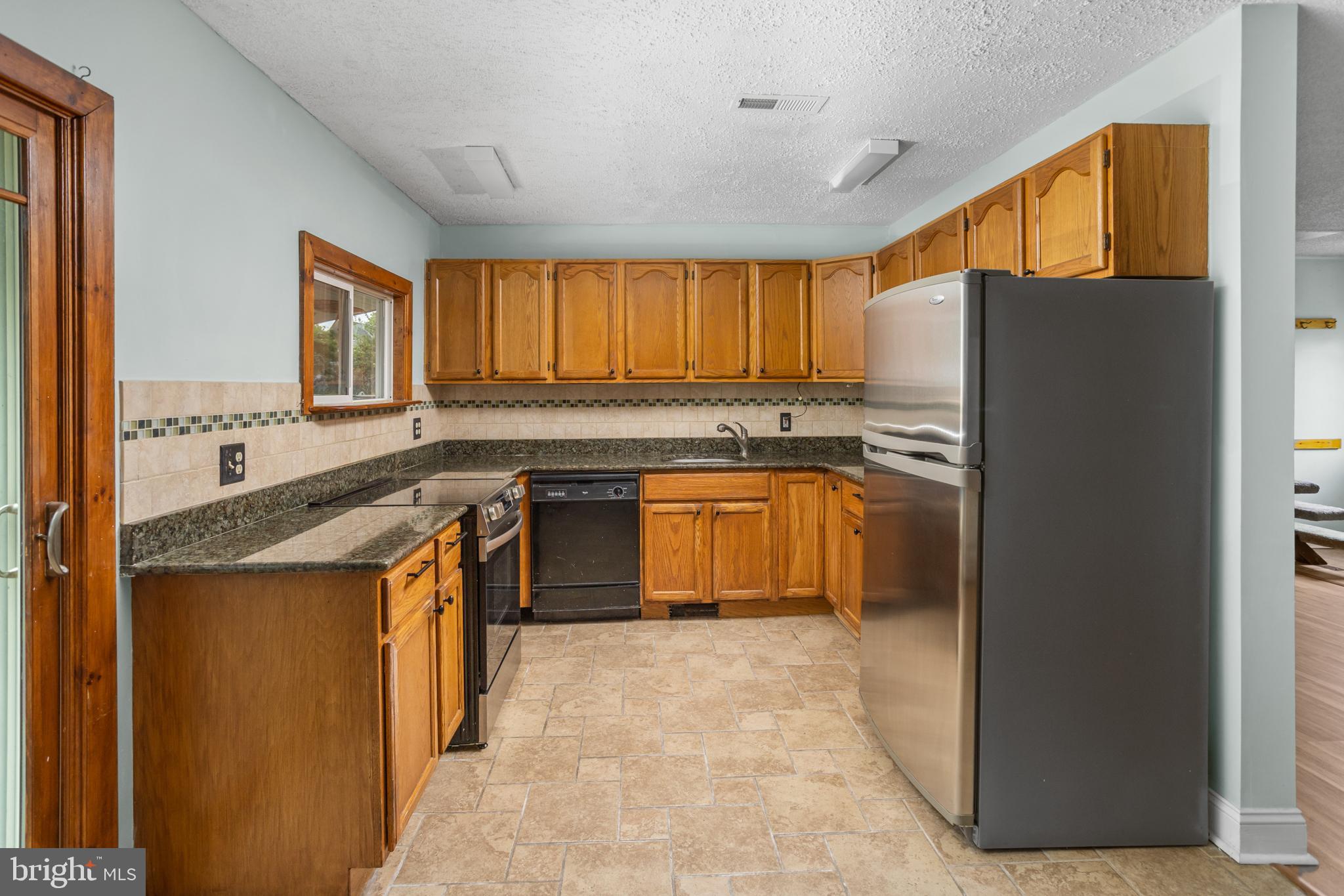 23 Cotton Road Levittown, PA 19057 - Photo 10 of 36 a kitchen with stainless steel appliances granite countertop a stove a sink and a refrigerator