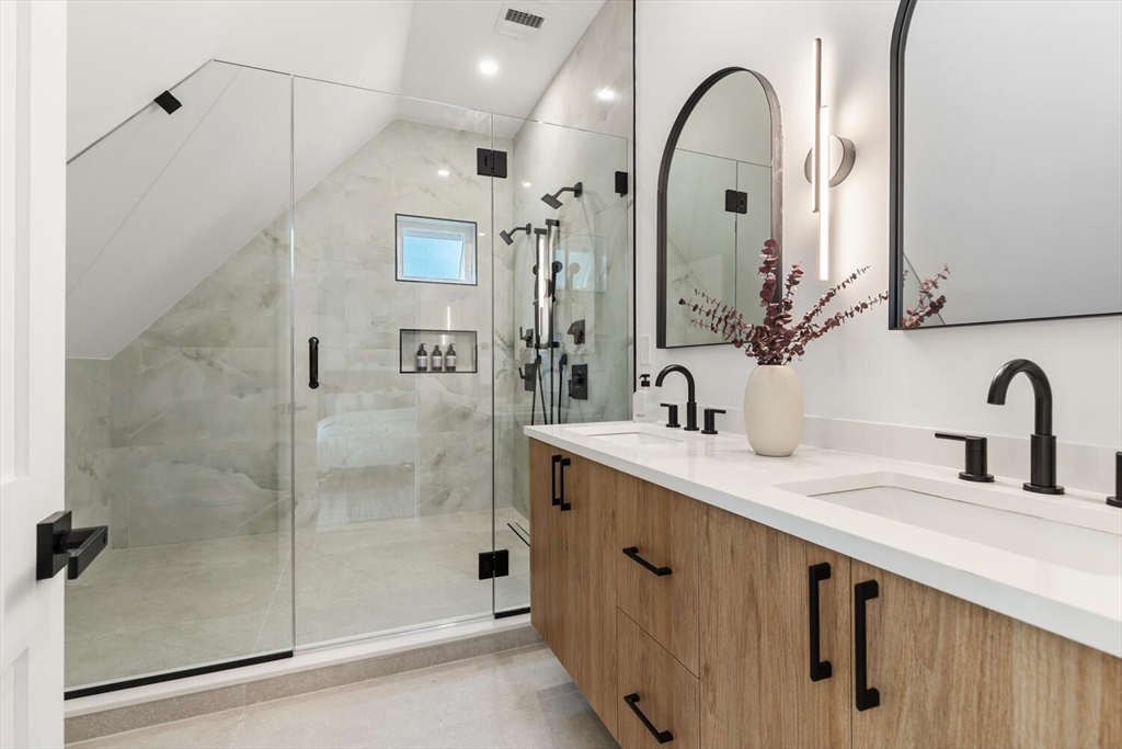 6 Wyman Court, Unit 6 Winchester, MA 01890 - Photo 20 of 35 a bathroom with a double vanity sink mirror and shower