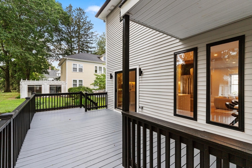 6 Wyman Court, Unit 6 Winchester, MA 01890 - Photo 30 of 35 a view of a deck with wooden floor and fence with a large window