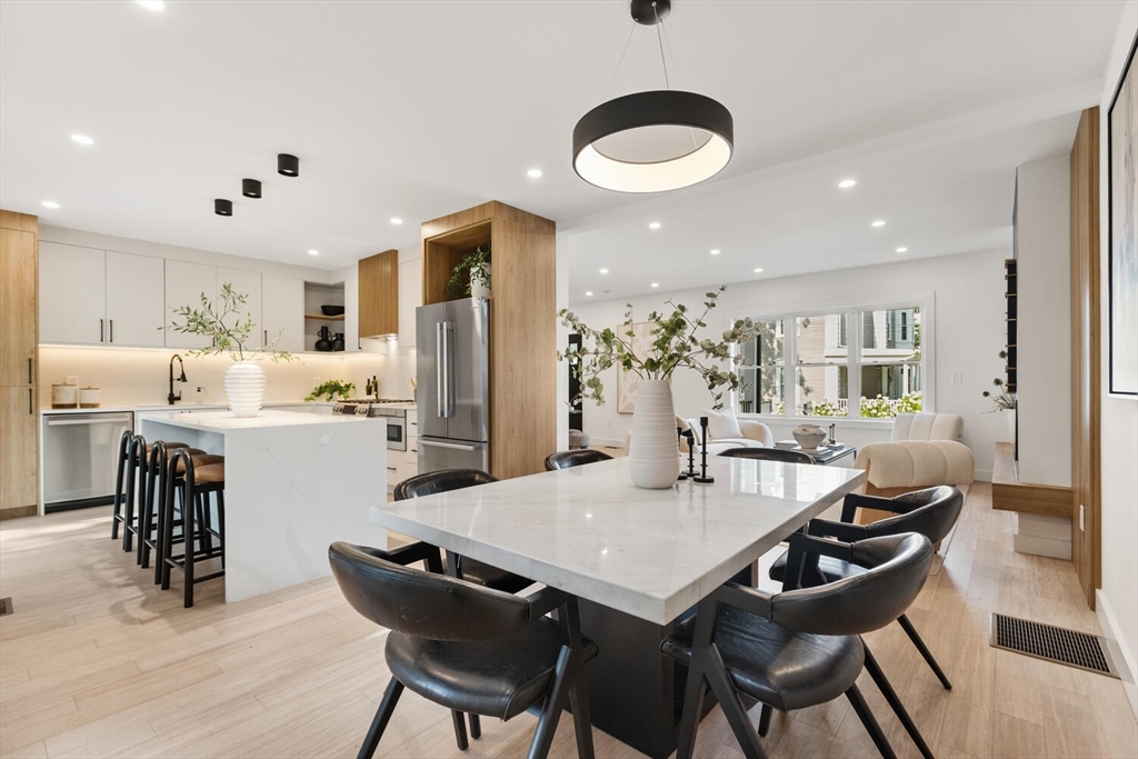 6 Wyman Court, Unit 6 Winchester, MA 01890 - Photo 5 of 35 a dining room with stainless steel appliances kitchen island granite countertop a dining table and chairs