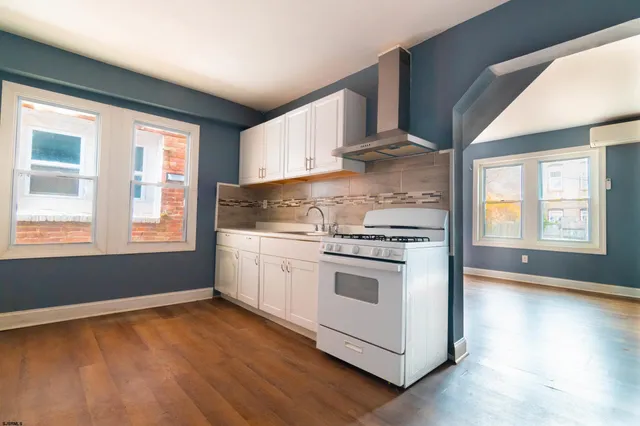 a kitchen with a stove a sink and a window