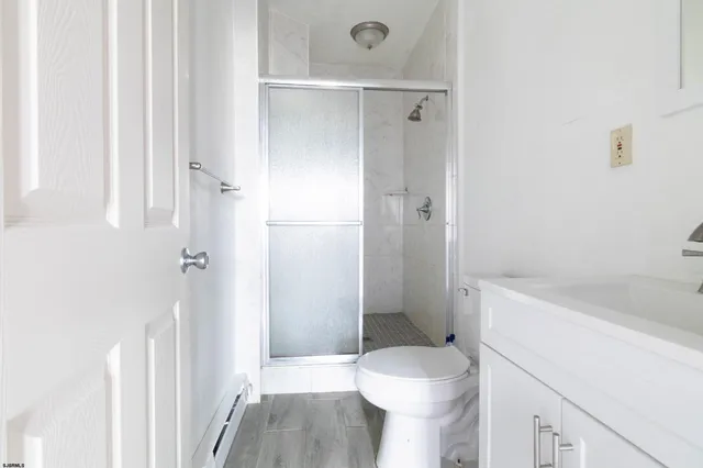 a bathroom with a sink a toilet and shower