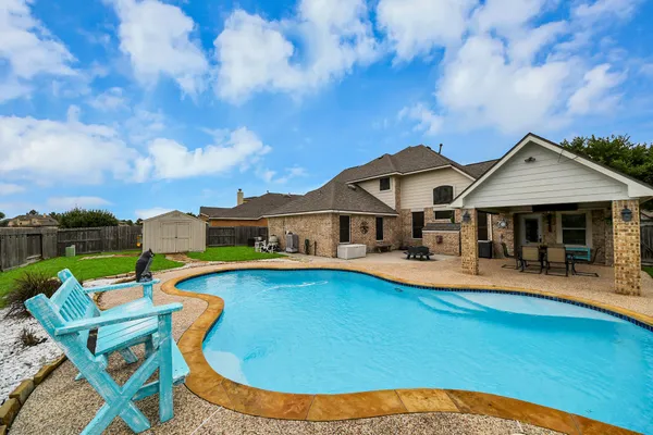 a view of a house with swimming pool and sitting area